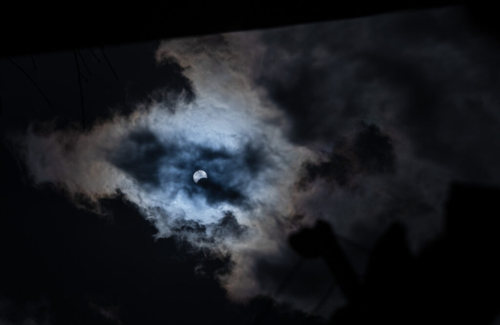 Partial Solar Eclipse reflected in a bucket of water, Colchester, Essex, UK